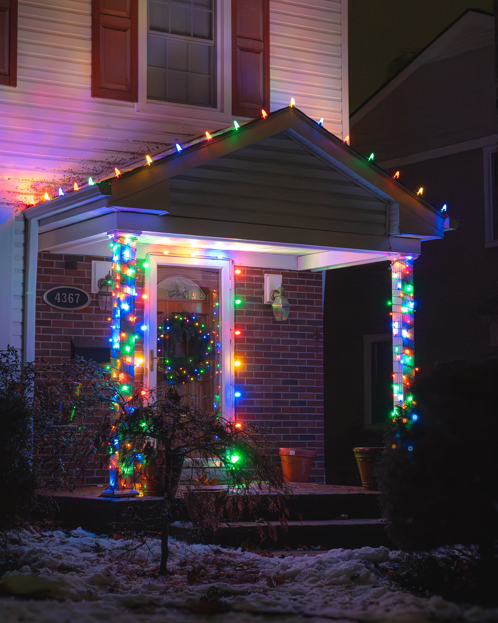 Front porch with multicolored lights along its roof and around columns